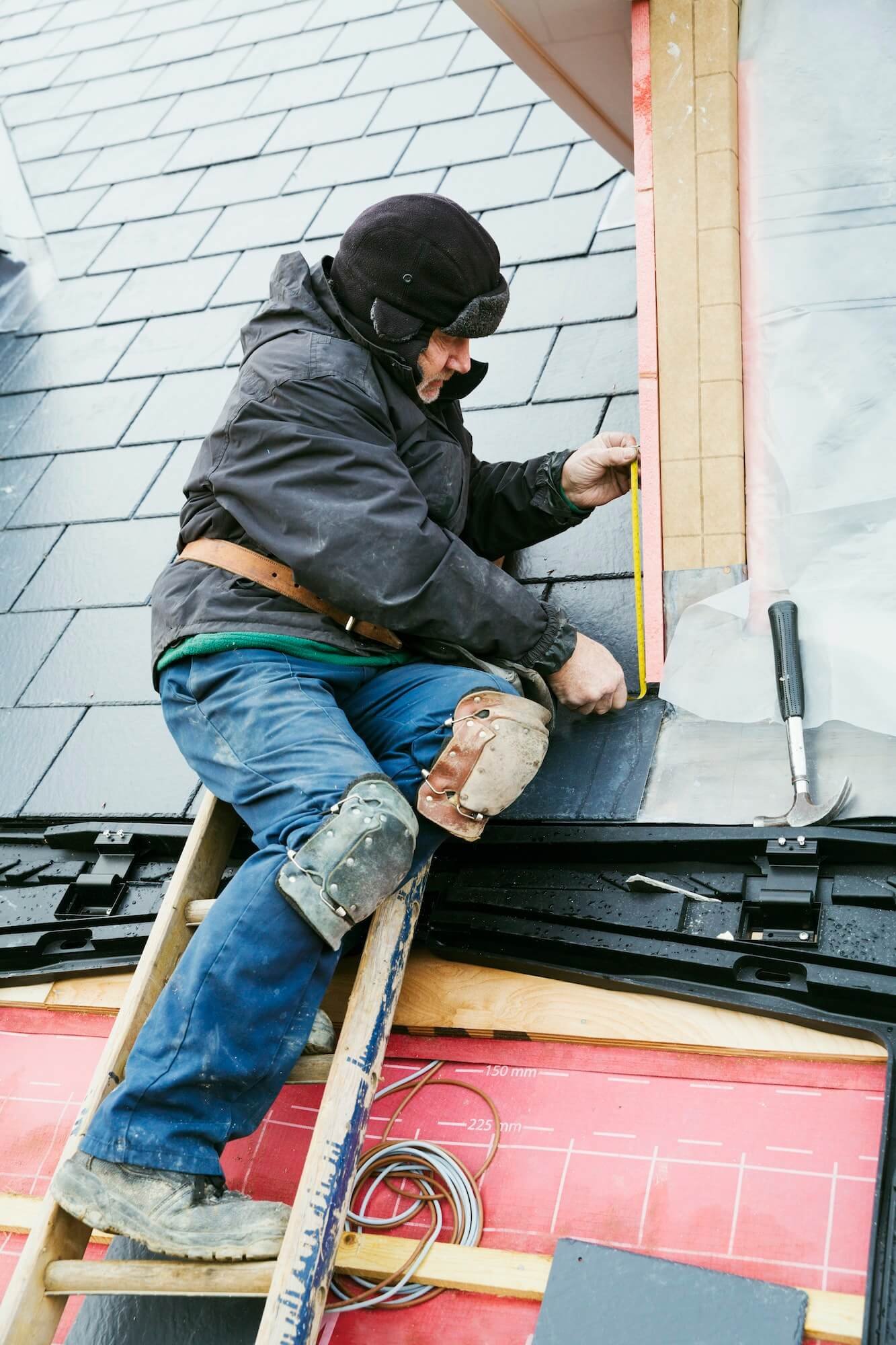 a-man-at-the-top-of-a-ladder-on-a-house-roof-fixing-tiles-on-a-dormer-roof-1-1-1.jpg